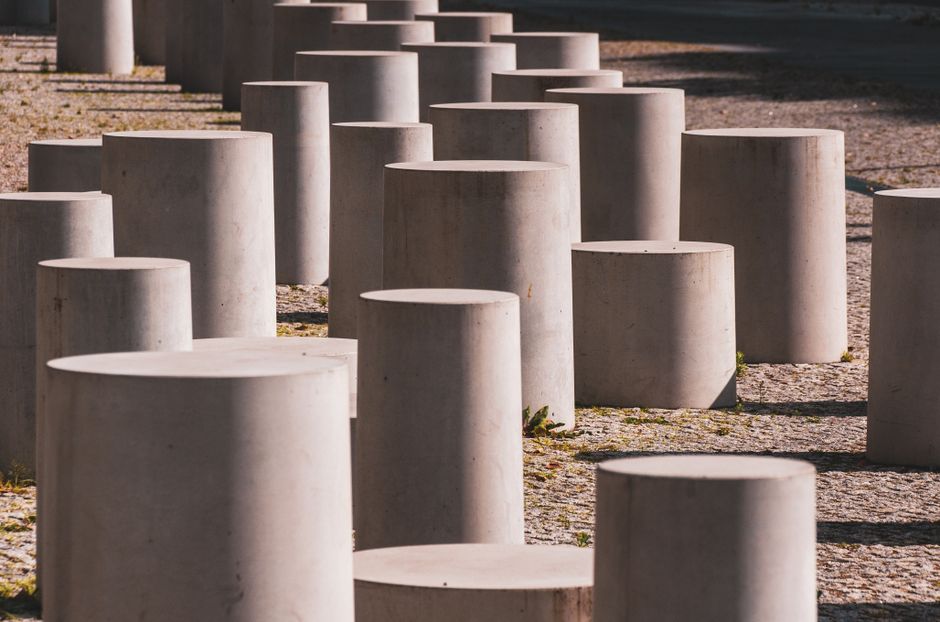 Abstract view of cylindrical concrete blocks arranged outdoors, creating a modern urban feel.